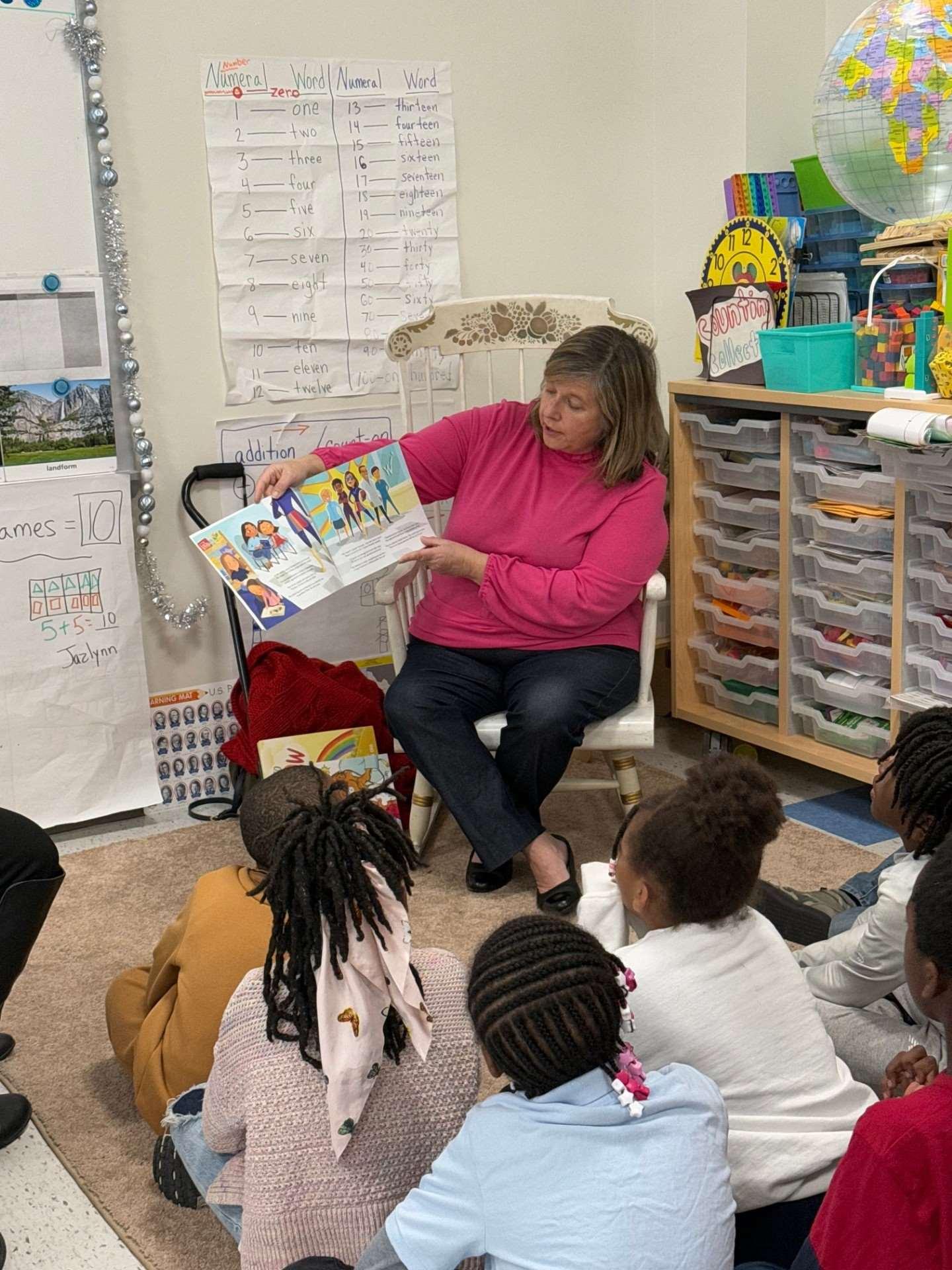 Teacher reading a picture book to children in a classroom
